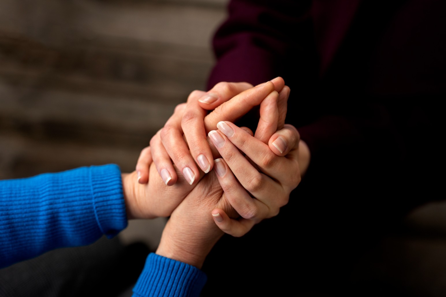 Mãos entrelaçadas em gesto de apoio e solidariedade familiar